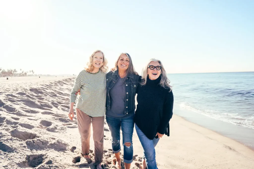senior friends walking near the ocean
